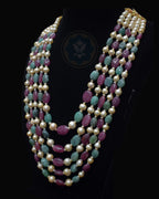 Side view of Indian Zevar five-string necklace set featuring big-size ruby beads, big-size emerald beads, freshwater pearls, CZ Polki and matching earrings.