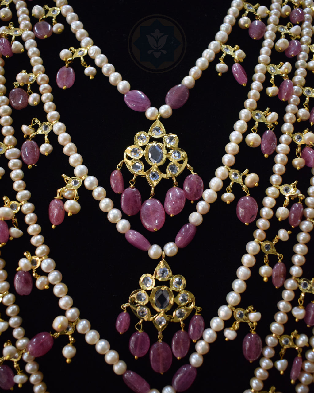 Close-up view of Indian Zevar Grand Ruby Sathlada with seven strings of real freshwater pearls, Bangkok Ruby GF beads, CZ Polki, Jadau hangings and matching Angoor Goshe chandelier earrings.