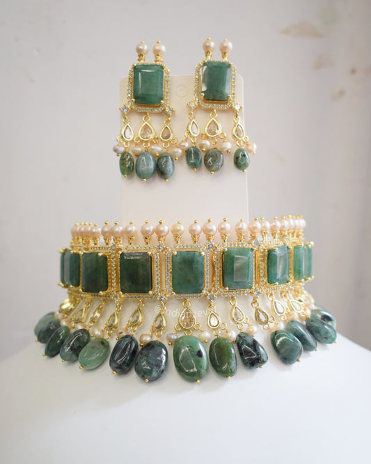 Green stone jewelry set on a mannequin with a white background. Indo-Western emerald green choker necklace set with pearls & CZ stones – Indian bridal jewelry, Hyderabadi pearl choker necklace online.