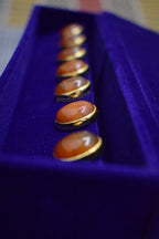 Traditional Indian men's button accessory with orange Hakik gemstones, set on alloy base in Jadau work.