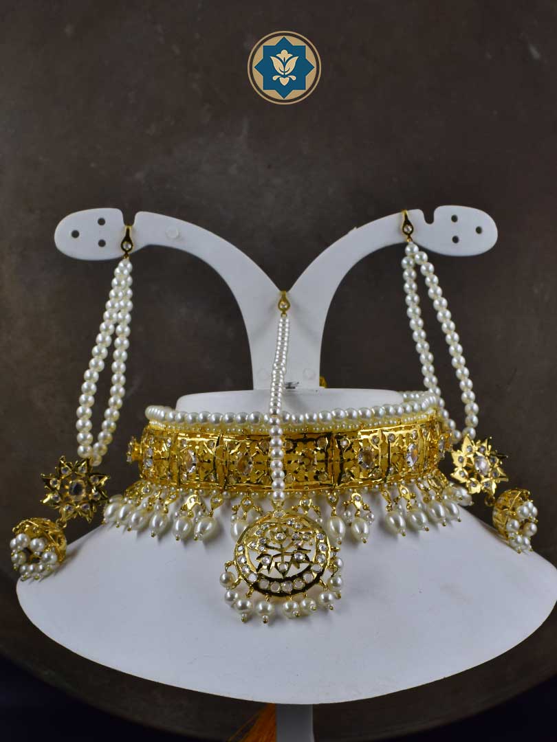 Complete your traditional look with our handmade Classic Hyderabadi Choker Set. Featuring faux pearls and intricate design, this set includes a Maang Tikka and matching Jhumka earrings. Perfect for adding a touch of elegance to any outfit.