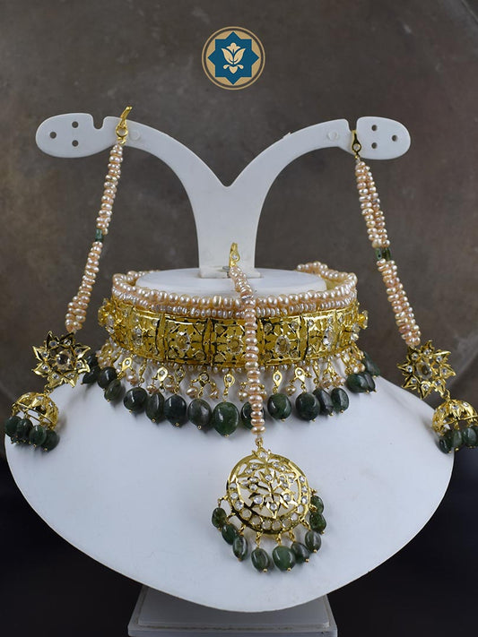 Get the complete traditional look with our Classic Hyderabadi Choker Set, including a Maang Tikka and Jhumka pair. Handcrafted with real freshwater old pearls and dark emeralds, this set is a true work of art